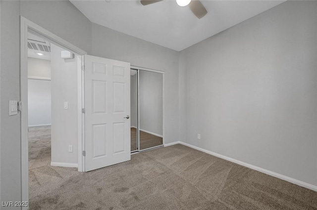 unfurnished bedroom featuring carpet floors, baseboards, a closet, and a ceiling fan