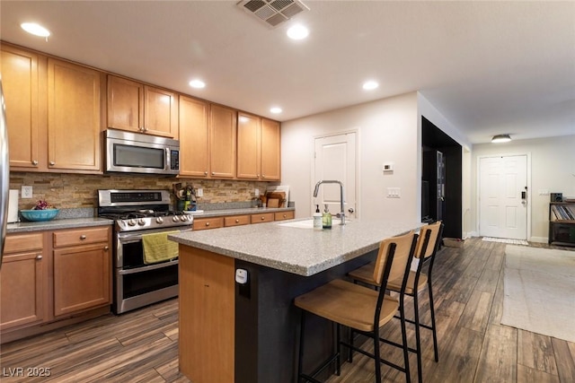 9925 Turquoise Glass Ct, Las Vegas, NV 89178 - kitchen featuring stainless steel appliances, a sink, tasteful backsplash, dark wood-style flooring, and recessed lighting