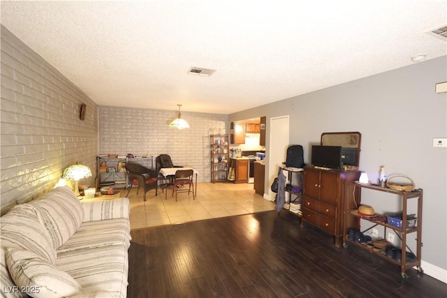 3008 Saint George St Unit B, North Las Vegas, NV 89030 - living room with brick wall, light wood-type flooring, and a textured ceiling