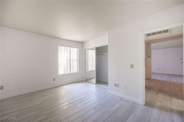 2606 S Durango Dr Unit 122, Las Vegas, NV 89117 - unfurnished bedroom with light wood-type flooring, baseboards, and a closet