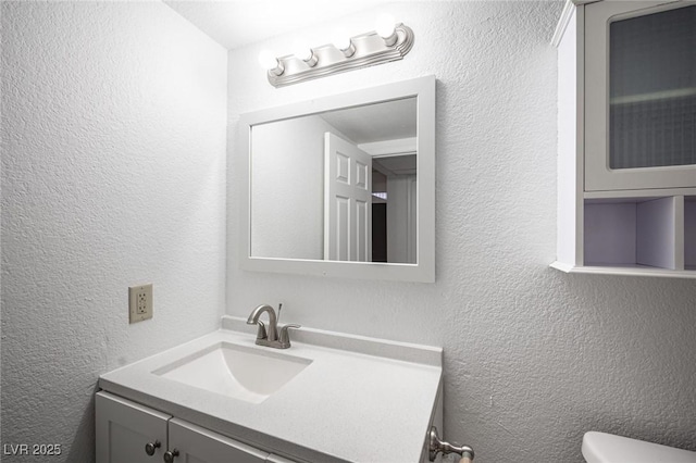 2606 S Durango Dr Unit 122, Las Vegas, NV 89117 - bathroom with a textured wall, vanity, and toilet