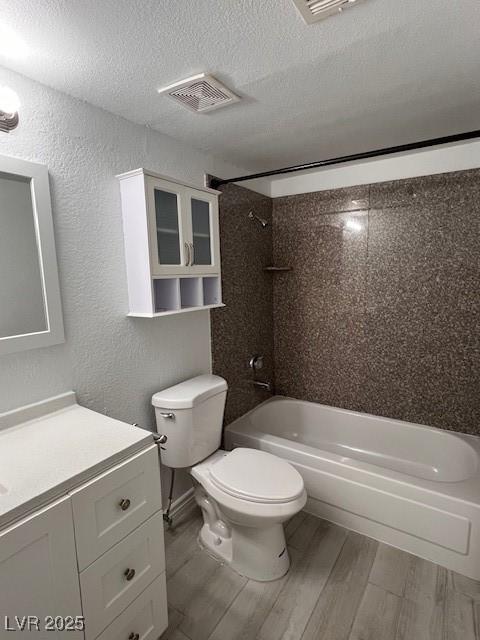 2606 S Durango Dr Unit 122, Las Vegas, NV 89117 - full bathroom featuring toilet, bathtub / shower combination, wood finished floors, vanity, and a textured ceiling