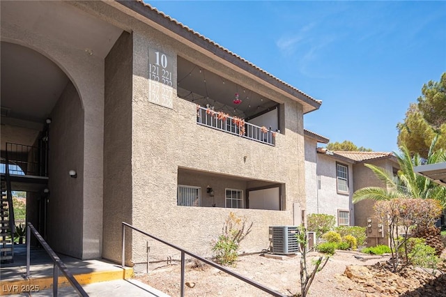 2606 S Durango Dr Unit 122, Las Vegas, NV 89117 - view of property exterior featuring stucco siding, central air condition unit, and a tile roof