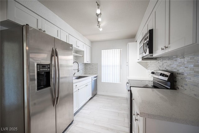 2606 S Durango Dr Unit 122, Las Vegas, NV 89117 - kitchen with appliances with stainless steel finishes, a sink, backsplash, and white cabinetry