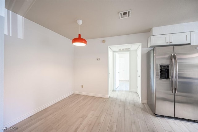 2606 S Durango Dr Unit 122, Las Vegas, NV 89117 - kitchen with stainless steel fridge with ice dispenser, light wood finished floors, baseboards, white cabinetry, and pendant lighting
