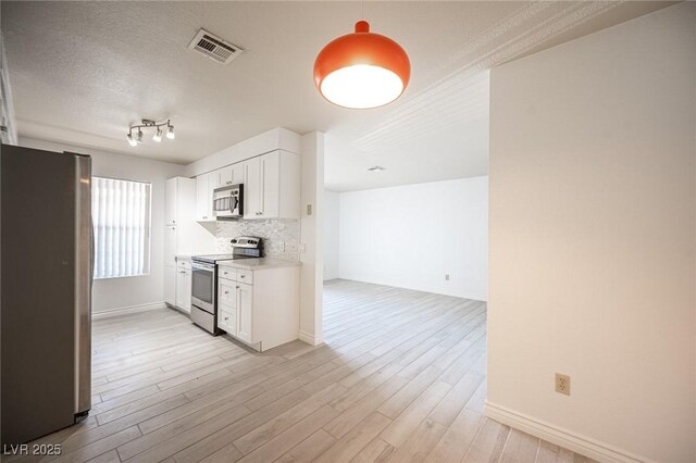 2606 S Durango Dr Unit 122, Las Vegas, NV 89117 - kitchen with stainless steel appliances, white cabinetry, light countertops, baseboards, and a textured ceiling