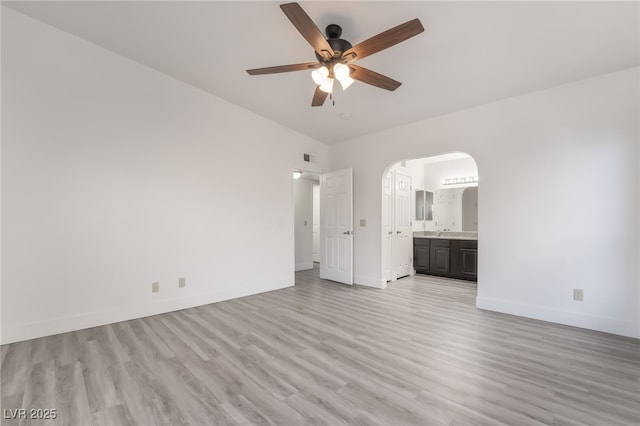 611 Bass Dr Unit C, Henderson, NV 89014 - unfurnished bedroom with light wood-type flooring, baseboards, arched walkways, and ensuite bath