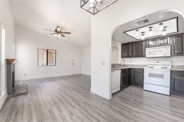 611 Bass Dr Unit C, Henderson, NV 89014 - kitchen with white appliances, arched walkways, vaulted ceiling, ceiling fan, and light wood-style flooring
