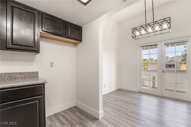 611 Bass Dr Unit C, Henderson, NV 89014 - bar area with light wood finished floors, french doors, baseboards, arched walkways, and hanging light fixtures