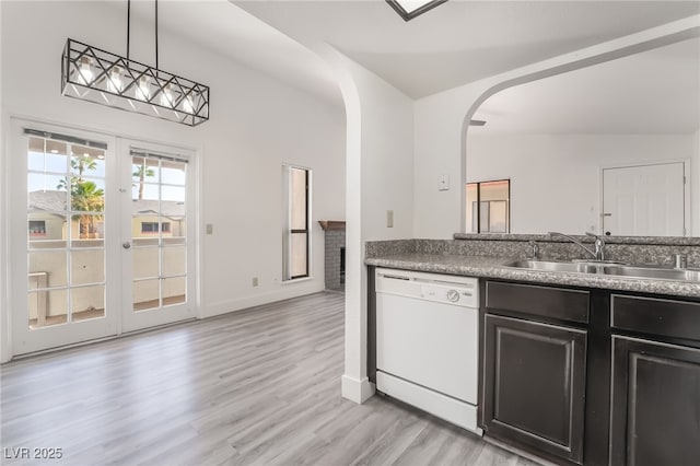 611 Bass Dr Unit C, Henderson, NV 89014 - kitchen with dishwasher, a sink, light wood-type flooring, arched walkways, and dark cabinets