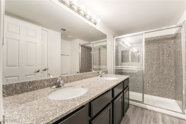 611 Bass Dr Unit C, Henderson, NV 89014 - full bathroom with double vanity, a shower stall, and wood finished floors