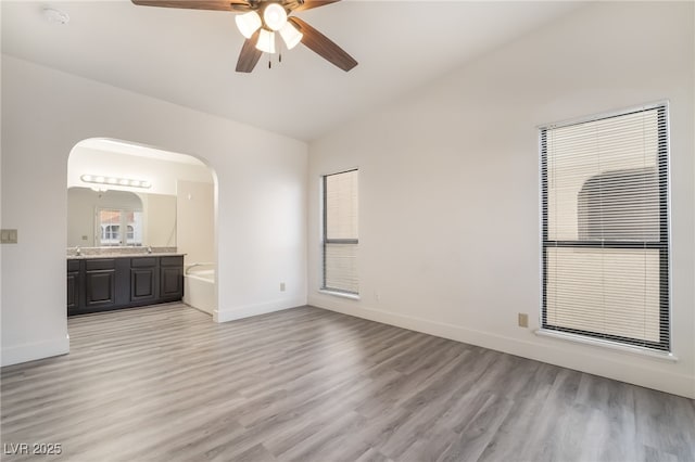 611 Bass Dr Unit C, Henderson, NV 89014 - unfurnished room featuring lofted ceiling, arched walkways, ceiling fan, baseboards, and light wood-style floors