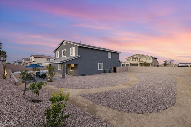 5449 Hickory Tree St, Las Vegas, NV 89149 - back of property at dusk with stucco siding, a fenced backyard, a patio area, and central air condition unit