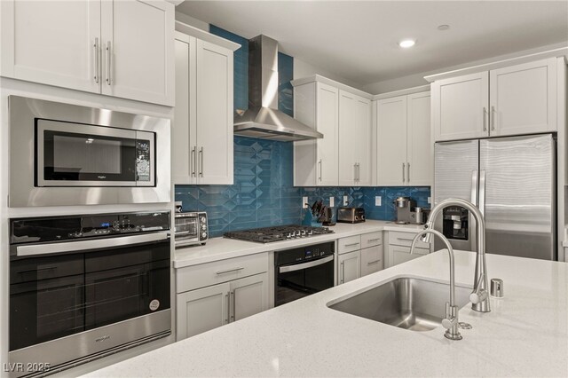 5449 Hickory Tree St, Las Vegas, NV 89149 - kitchen featuring stainless steel appliances, wall chimney exhaust hood, a sink, backsplash, and white cabinets