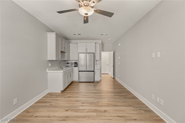5449 Hickory Tree St, Las Vegas, NV 89149 - kitchen with stainless steel refrigerator, light countertops, a ceiling fan, light wood finished floors, and baseboards