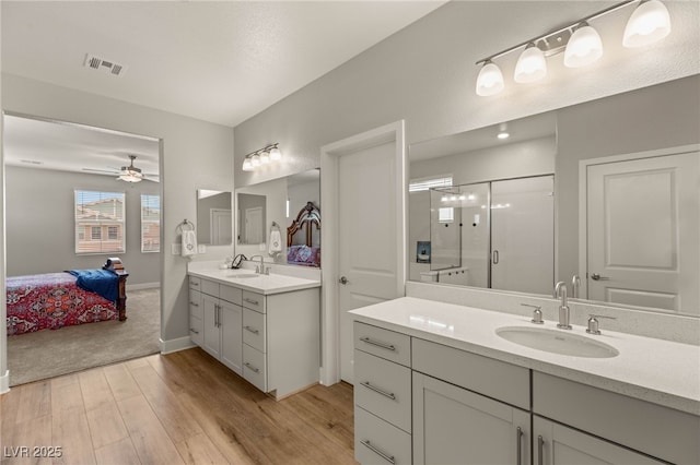 5449 Hickory Tree St, Las Vegas, NV 89149 - bathroom featuring a stall shower, wood finished floors, two vanities, ceiling fan, and connected bathroom