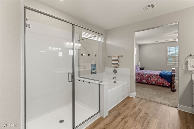 5449 Hickory Tree St, Las Vegas, NV 89149 - full bathroom featuring a stall shower, wood finished floors, ensuite bath, a garden tub, and baseboards