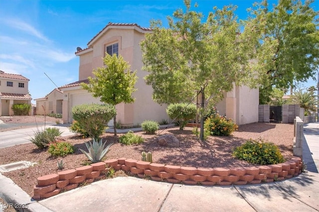 view of front of home with stucco siding, a garage, concrete driveway, and a tile roof