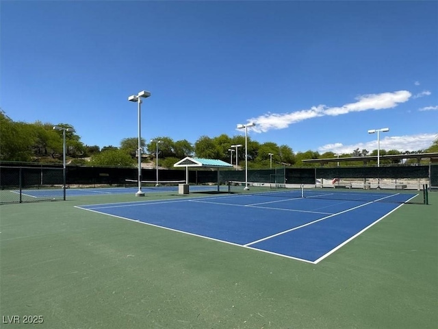 view of tennis court with fence and community basketball court