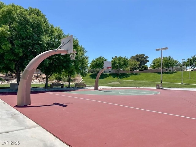 view of basketball court with community basketball court and a lawn