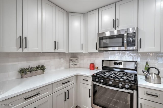 kitchen with appliances with stainless steel finishes, white cabinetry, and decorative backsplash