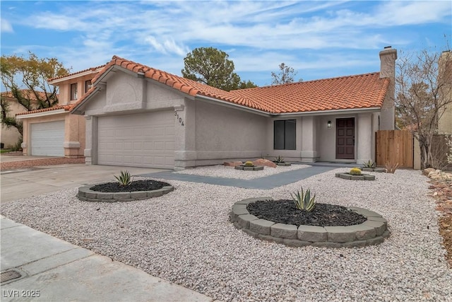 mediterranean / spanish house with an attached garage, stucco siding, fence, a tiled roof, and driveway