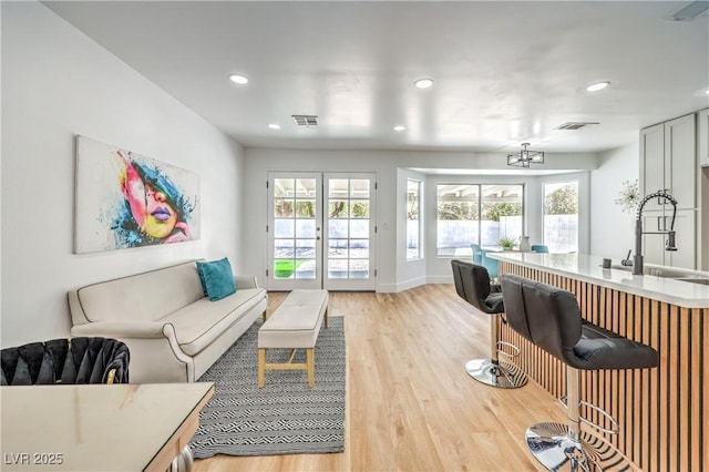 living area with light wood-type flooring, recessed lighting, and baseboards