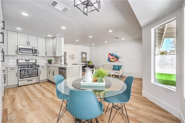 dining area with baseboards, recessed lighting, and light wood-style flooring