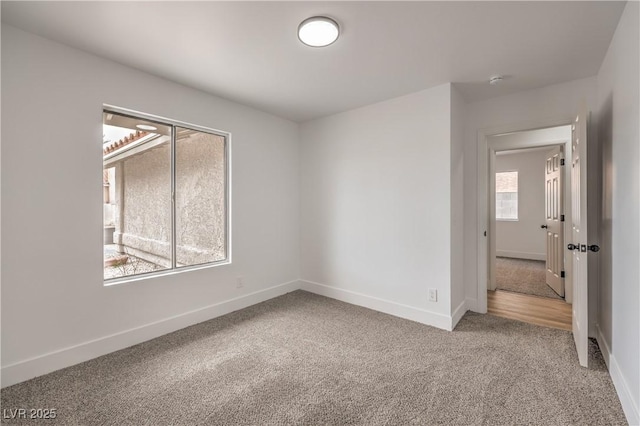 unfurnished room featuring carpet floors and baseboards