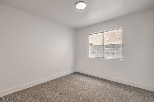 carpeted empty room featuring baseboards