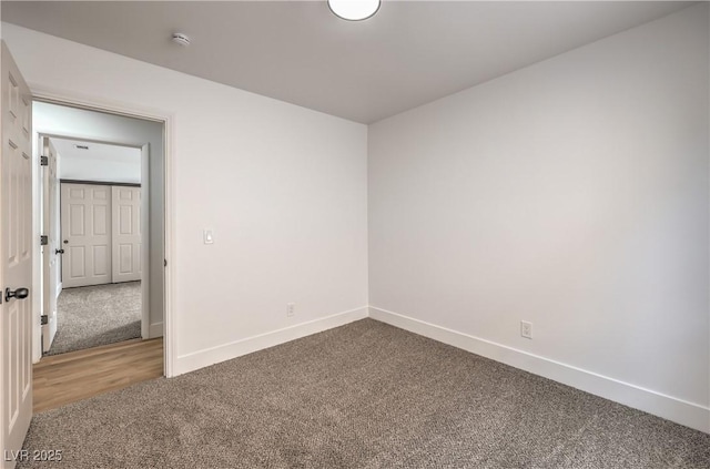 carpeted empty room with baseboards and a smoke detector