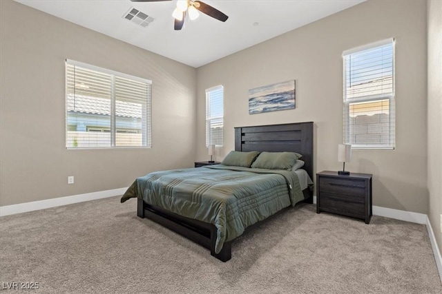 bedroom with light colored carpet, baseboards, and multiple windows