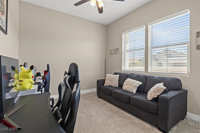 carpeted office space featuring ceiling fan and baseboards