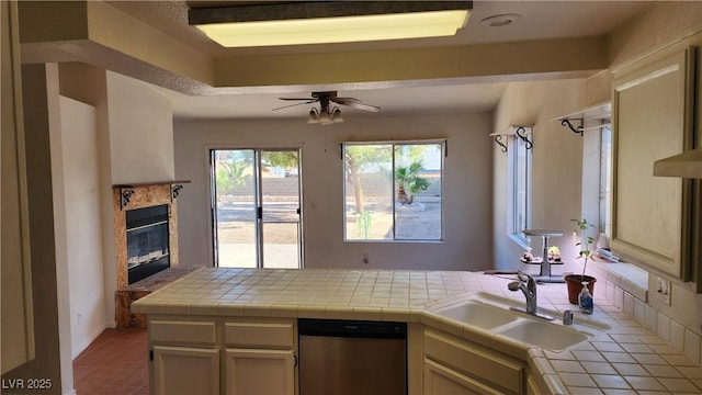 4285 El Como Way, Las Vegas, NV 89121 - kitchen featuring stainless steel dishwasher, tile countertops, ceiling fan, a premium fireplace, and a peninsula