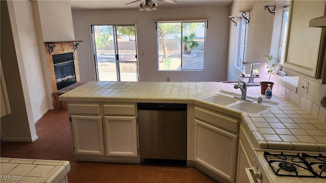 4285 El Como Way, Las Vegas, NV 89121 - kitchen featuring stainless steel dishwasher, tile counters, a high end fireplace, dark tile patterned floors, and a peninsula