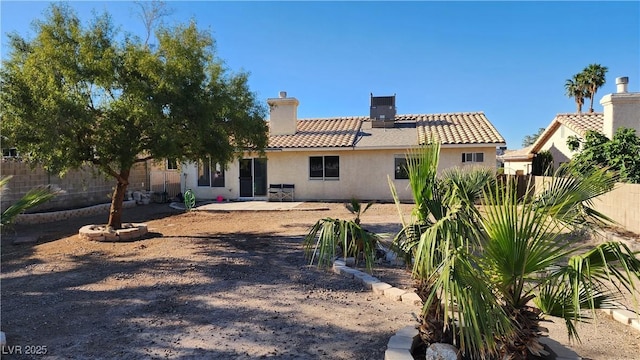 4285 El Como Way, Las Vegas, NV 89121 - rear view of house featuring stucco siding, fence, a tile roof, and a chimney