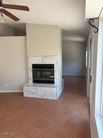 4285 El Como Way, Las Vegas, NV 89121 - unfurnished living room featuring a ceiling fan, a high end fireplace, and tile patterned flooring