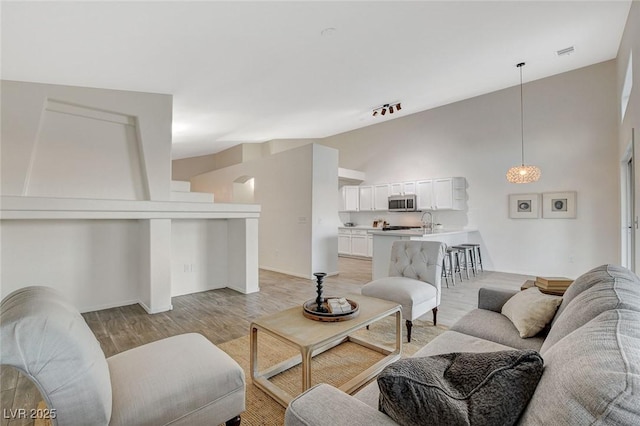 living room with light wood-style flooring and high vaulted ceiling