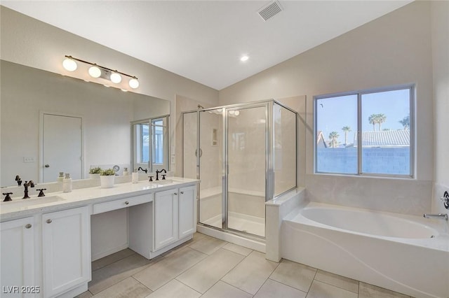 bathroom featuring tile patterned floors, lofted ceiling, a stall shower, a garden tub, and double vanity