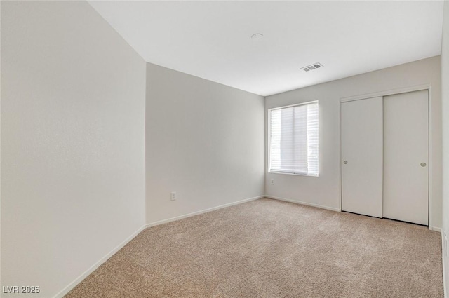 unfurnished bedroom with carpet floors, baseboards, and a closet
