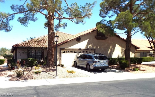 3954 Saddlewood Ct, Las Vegas, NV 89121 - view of front of property featuring stucco siding, a tile roof, an attached garage, and driveway