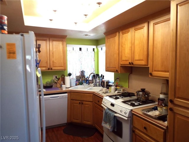 3954 Saddlewood Ct, Las Vegas, NV 89121 - kitchen featuring white appliances, a sink, a raised ceiling, and dark wood-type flooring