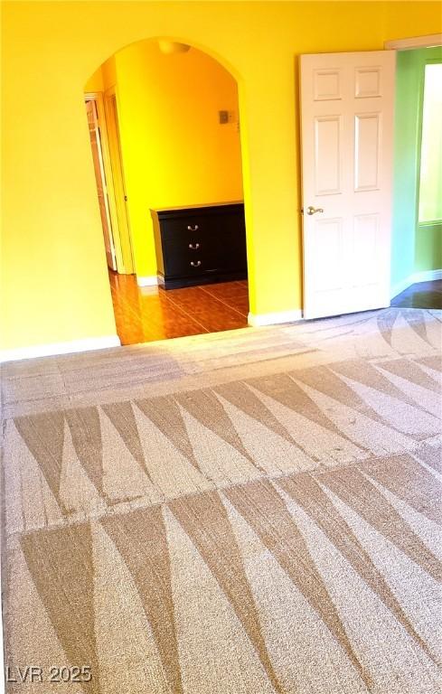 3954 Saddlewood Ct, Las Vegas, NV 89121 - unfurnished room with arched walkways, carpet floors, and baseboards