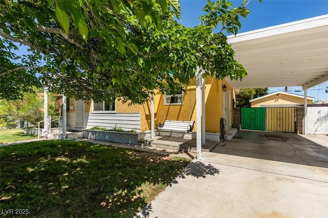 1127 Melville Dr, Las Vegas, NV 89102 - view of front facade featuring an attached carport, stucco siding, fence, a gate, and driveway