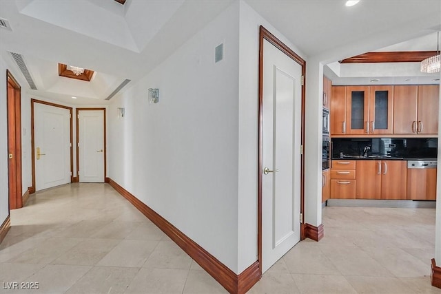 hallway featuring a raised ceiling, baseboards, light tile patterned floors, and recessed lighting