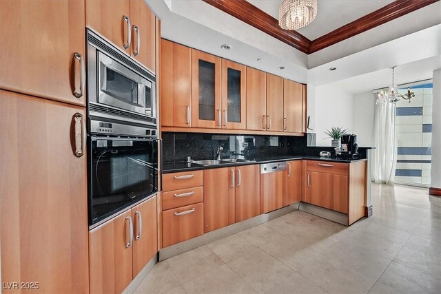 kitchen with black oven, a chandelier, ornamental molding, decorative backsplash, and stainless steel microwave