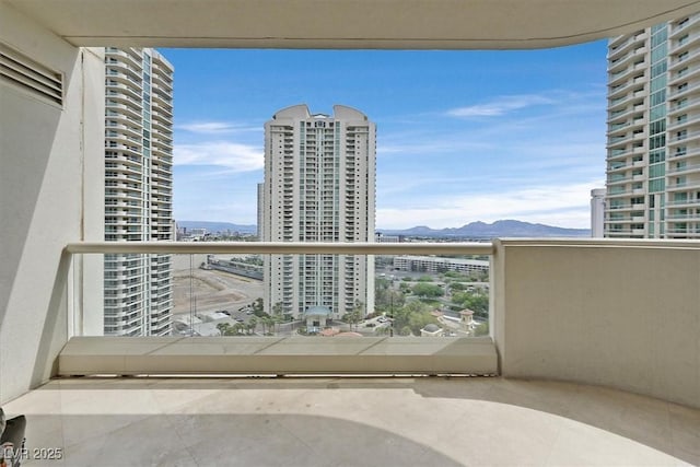 balcony with a mountain view and a view of city