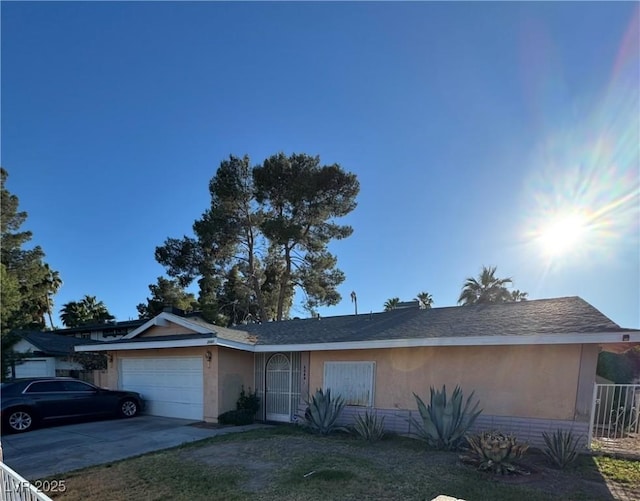 ranch-style house with stucco siding, a garage, and driveway