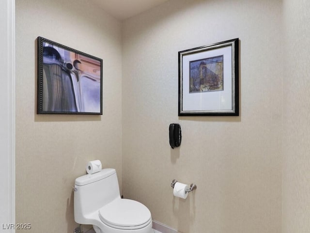 bathroom with toilet and baseboards