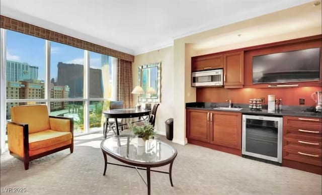 indoor wet bar featuring beverage cooler, white microwave, healthy amount of natural light, and light colored carpet